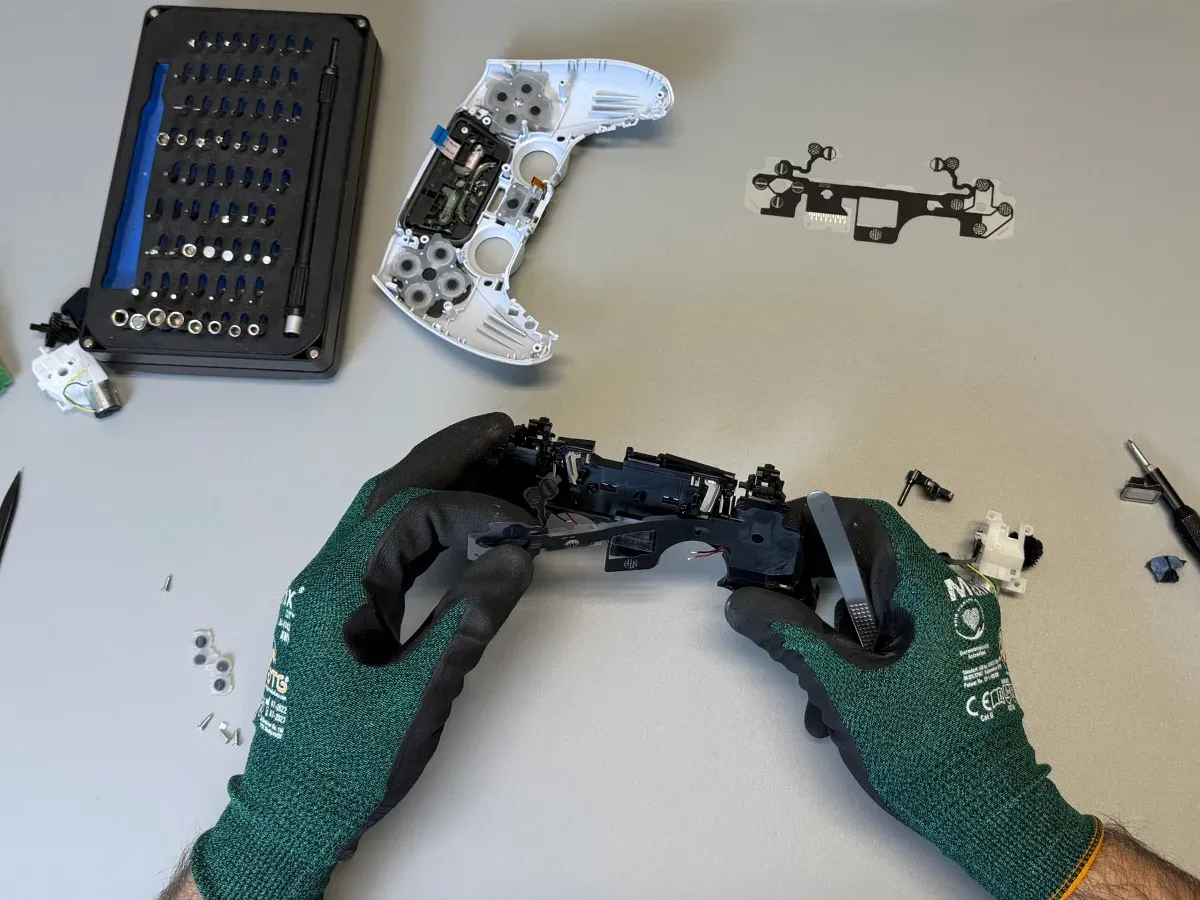 Tehnician desface un controller DualSense PS5 pe bancul de lucru